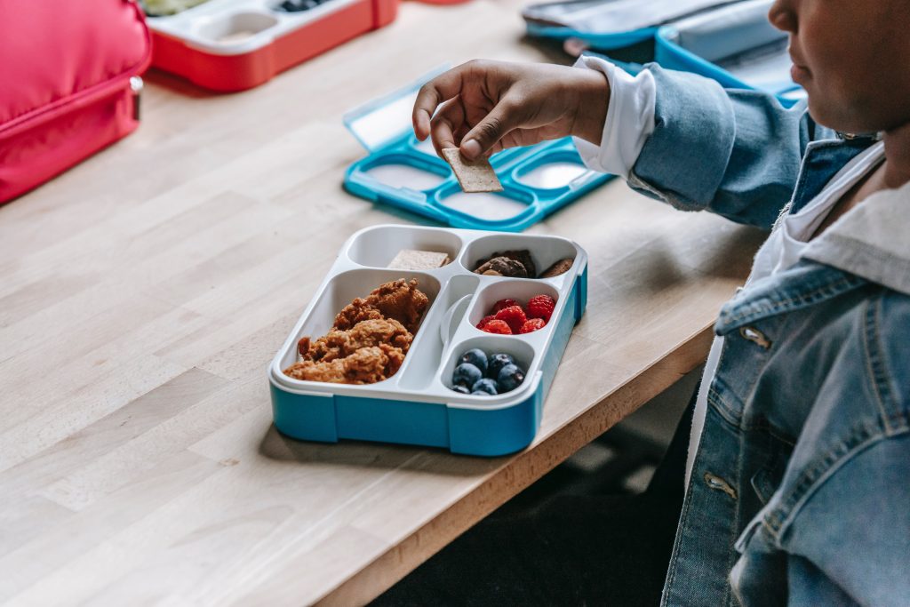 stock photo of kids' lunch for the program we support, shows diversity and community too