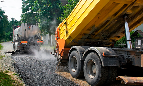 photo of dump truck pouring cement on pavement. 