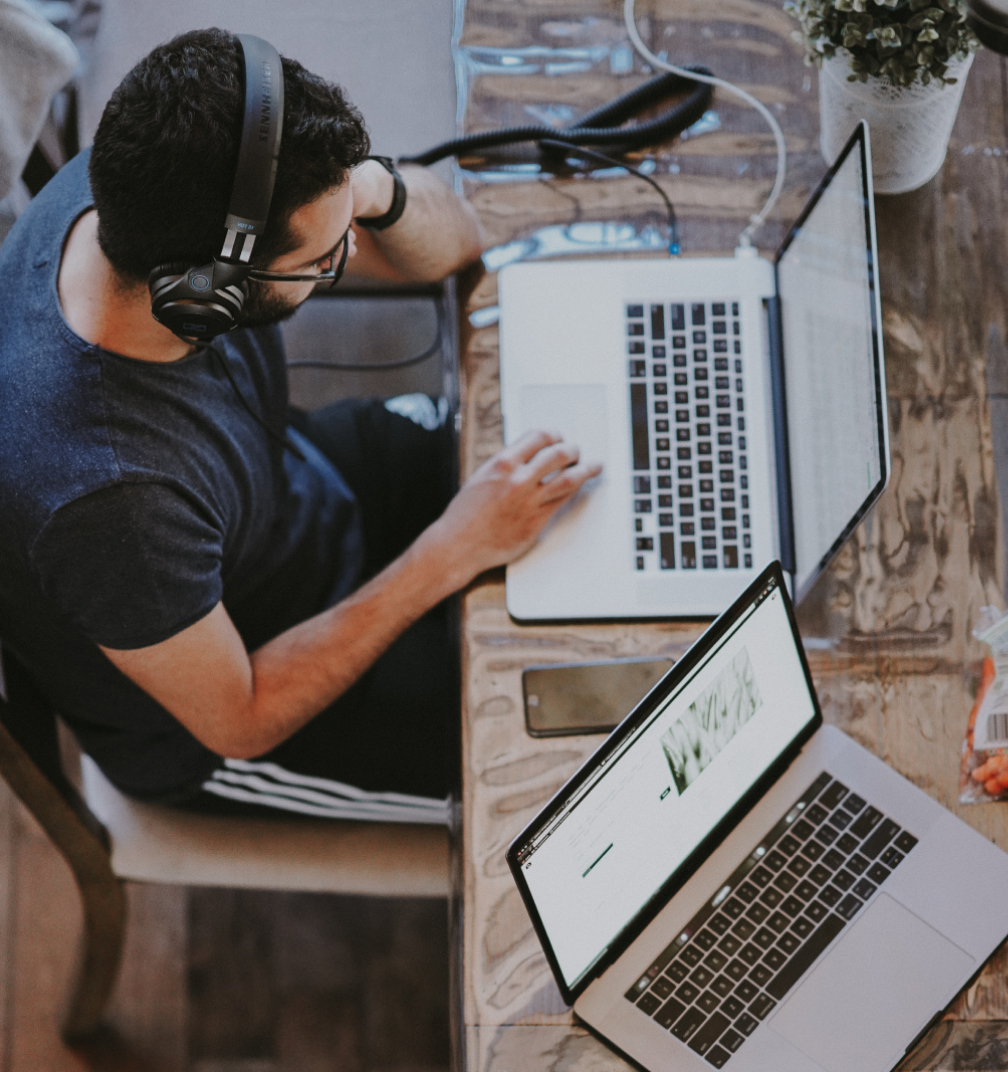 Man headphones two laptops