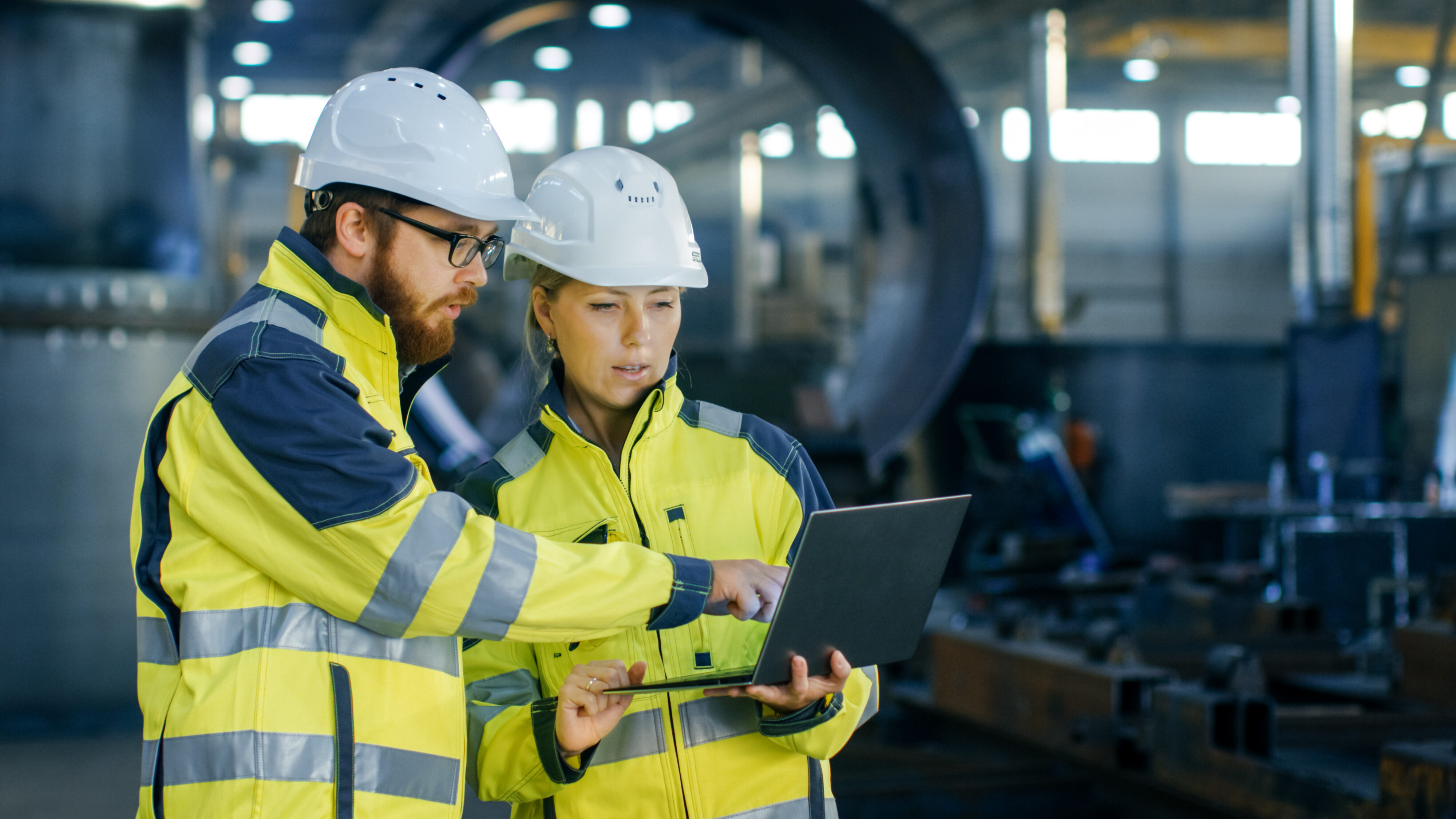 Two engineers review information from a tablet